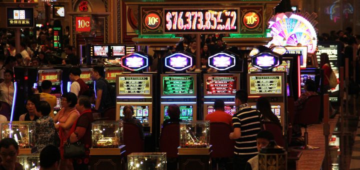 Photo d'un casino avec des gens installés sur des machines à sous